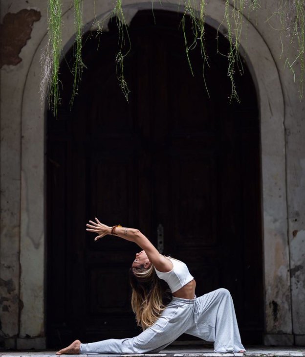 mulher com pose de yoga em frente a uma paisagem
